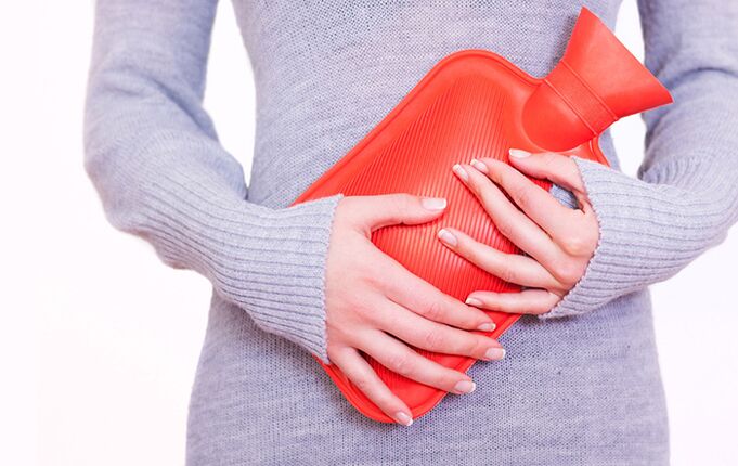 Applying a heating pad to the stomach will help relieve the symptoms of cystitis for a woman.